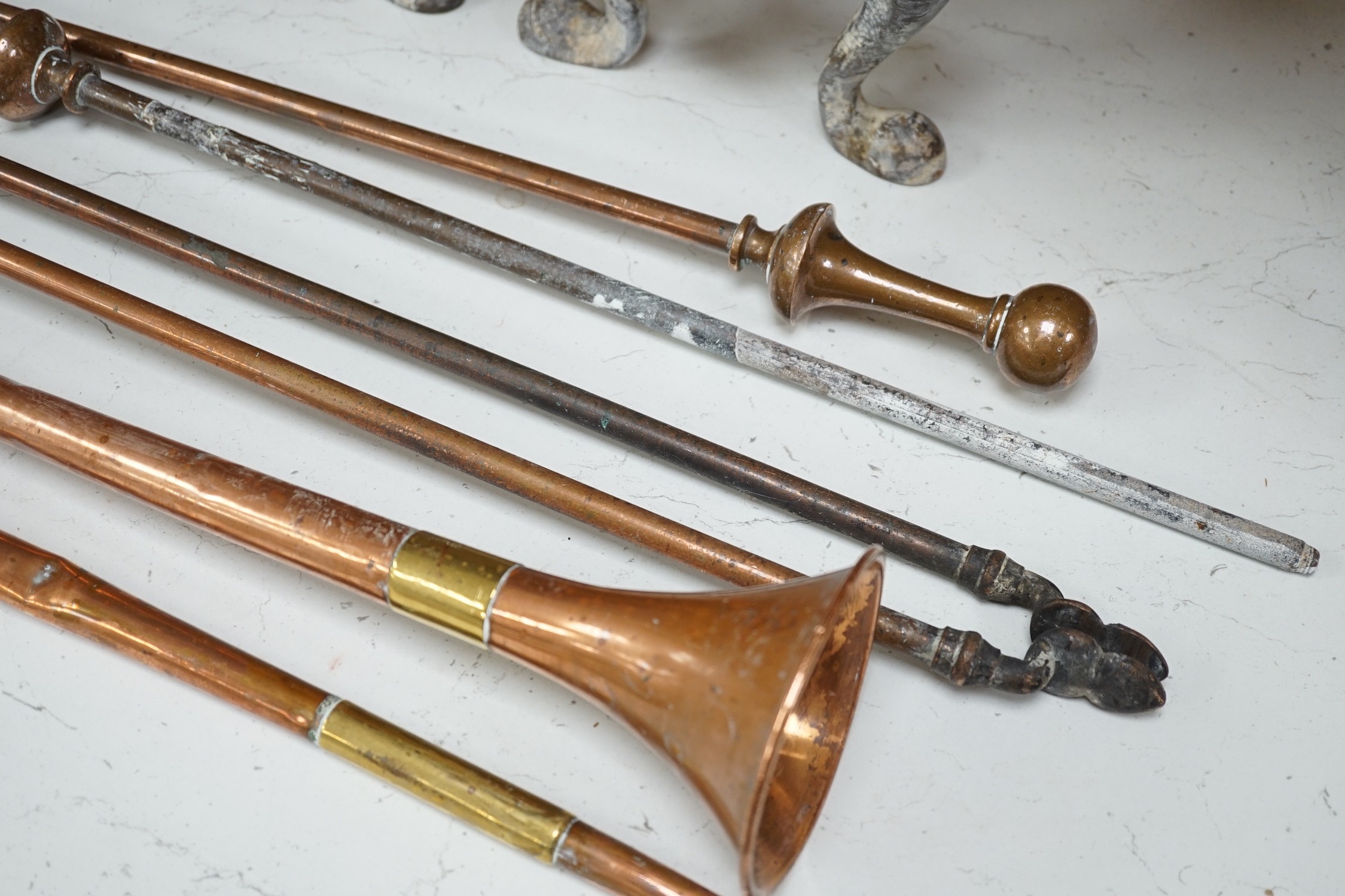 A pair of Arts and Crafts copper and iron fire dogs together with copper coaching horns, etc. (group)